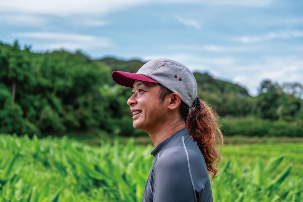 健太郎在秋葵田裡侃侃而談土壤與微生物間的共生關係。