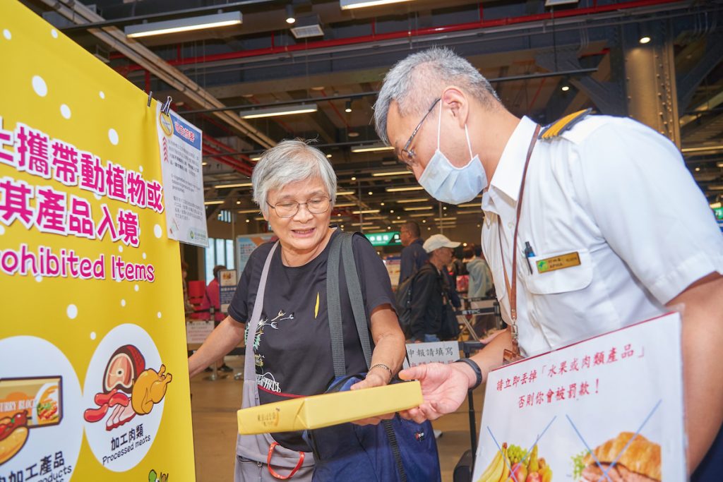 一位旅客主動拿出準備攜帶入境的食品，詢問李易諺是否合乎規定。