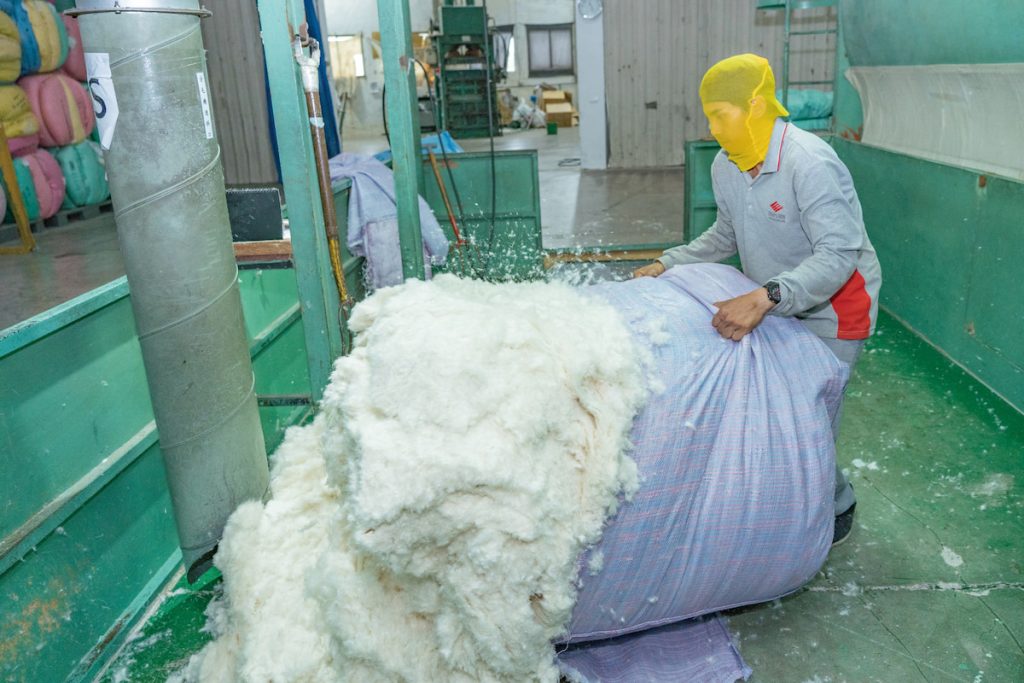 工人將預先處理過後的羽絨，再放入風吹機，進行風力分級。