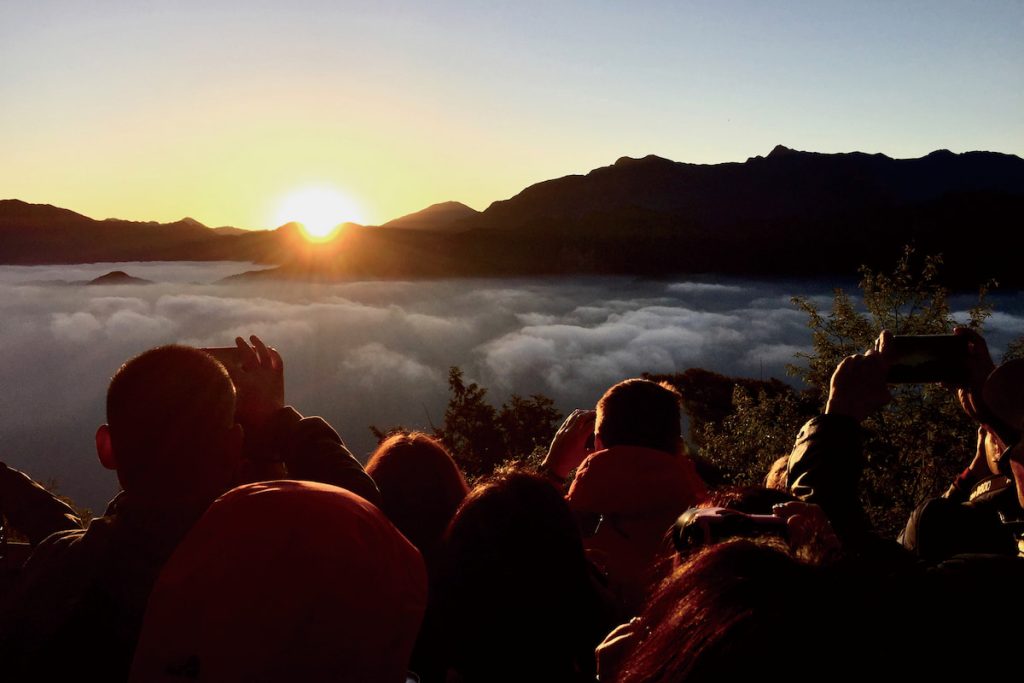 太陽越過山巒,金色的光線在雲海間流動。