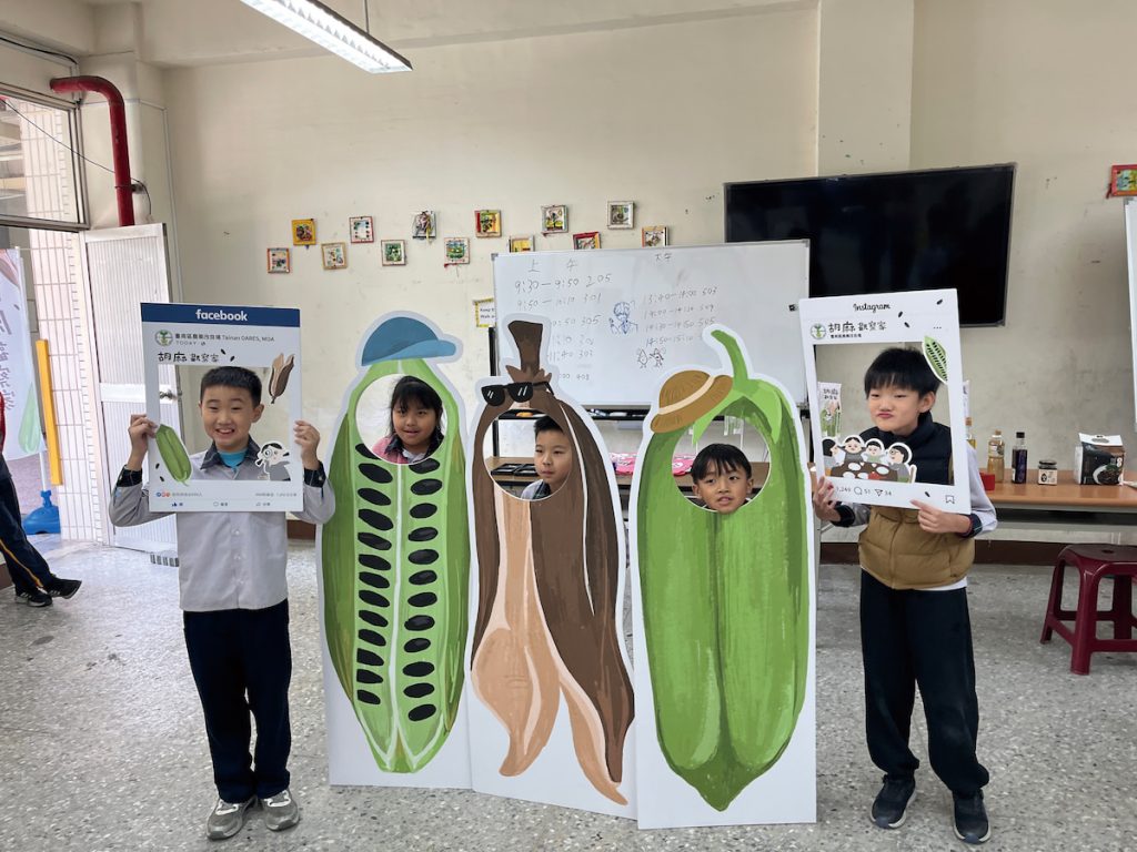 臺南農業改良場團隊帶著胡麻教材及教具入校，邀請學生一起闖關，課後 孩子們與胡麻立板開心合影。（圖片提供╱蔡永靖）