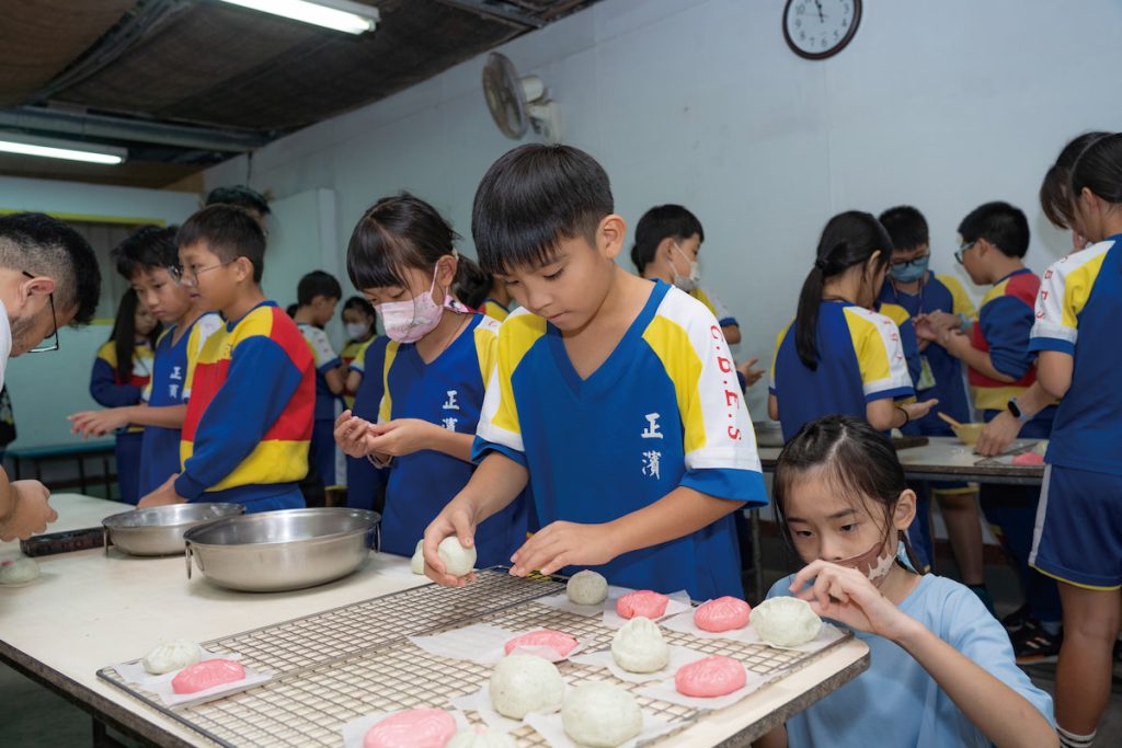 學生們開心親手做紅龜粿,包入雜糧紅豆餡。