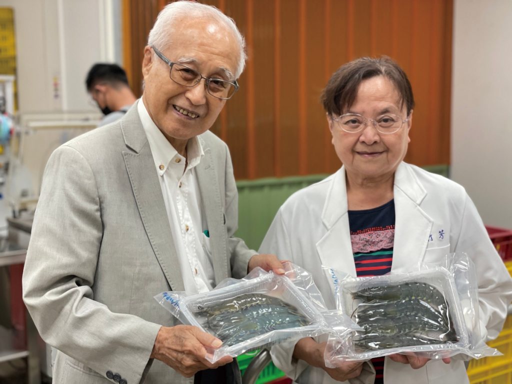 廖一久與羅竹芳手持養殖蝦種原培育中心所產出具食品安全的無抗無毒美味食用草蝦。