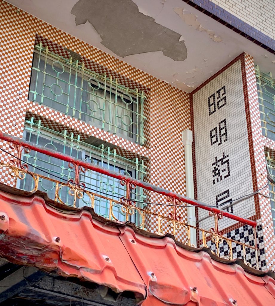 市場邊曾經氣派的藥局,還以磁磚貼出店名。