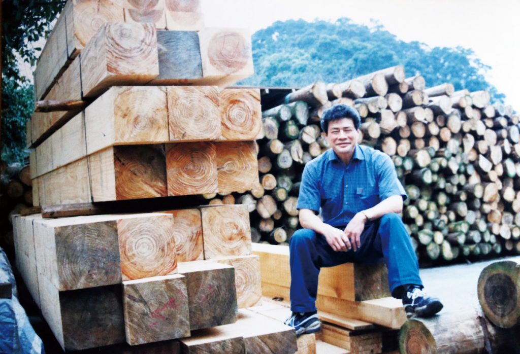 年輕時的梁兆清與自家生產的木材。(圖片提供/梁國興)