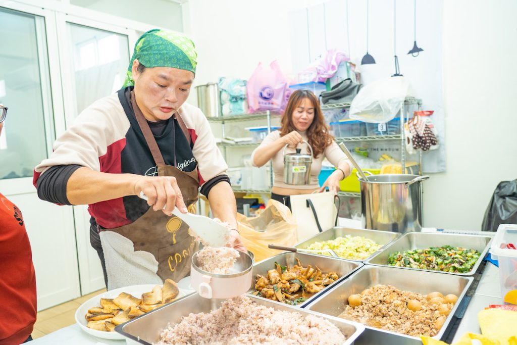 彰化區漁會新住民家政班成員，協助綠照站的共餐安排。圖中綠色頭巾者是班長陳惠貞。