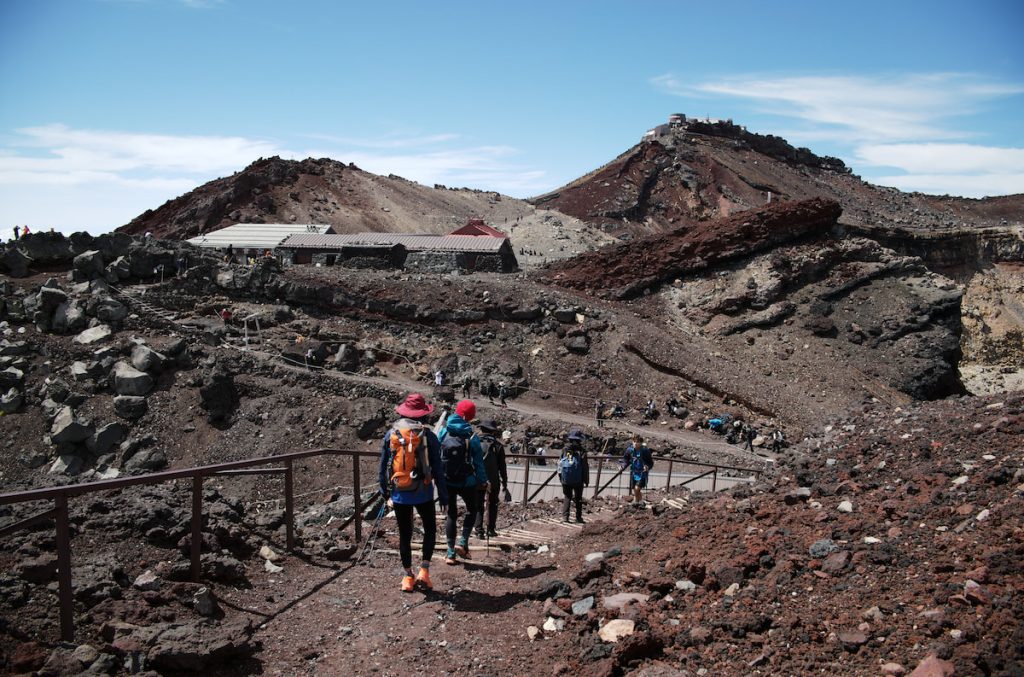 富士山火山口南緣的淺間大社頂上奧宮（中），與日本最高峰劍峰（右）。