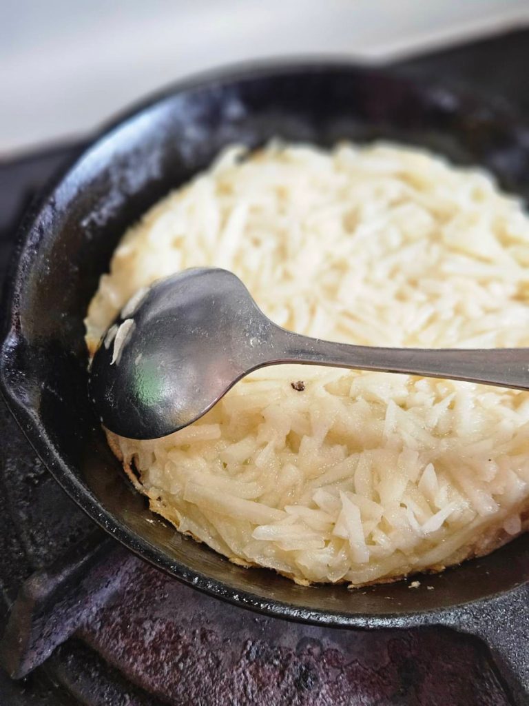 3 煎餅要用比較多的油，大概三大匙，中火熱鍋約一分鐘，轉小火三分鐘，然後用湯匙把馬鈴薯麵糊舀進鍋子裡壓平。過程中全部用小火慢煎，耐心等約五分鐘，可以用湯匙開始幫煎扁的邊緣塑型。