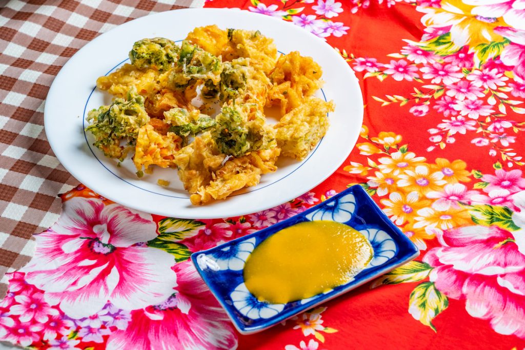 客家炸婆菜，把地瓜、芋頭、紅蘿蔔絲裹麵粉油炸，宛如另類客家天婦羅。