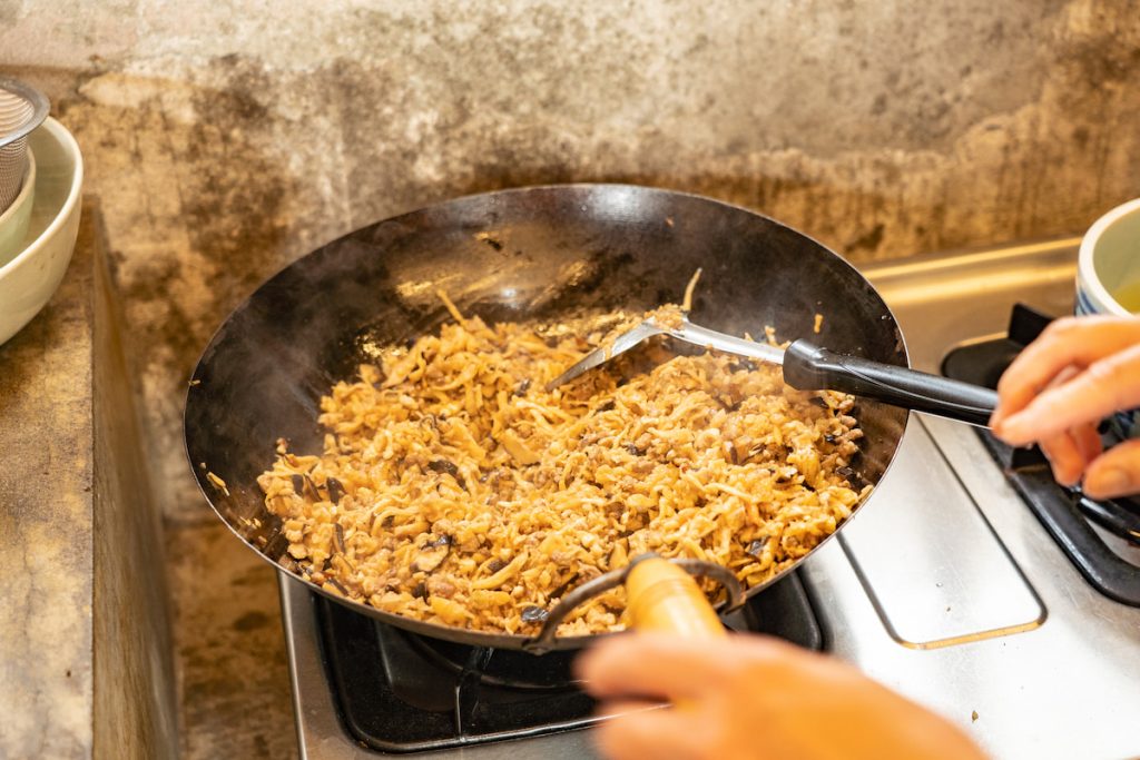 蘿蔔絲、香菇與肉末在鍋中翻炒,油香與醬油香交織。