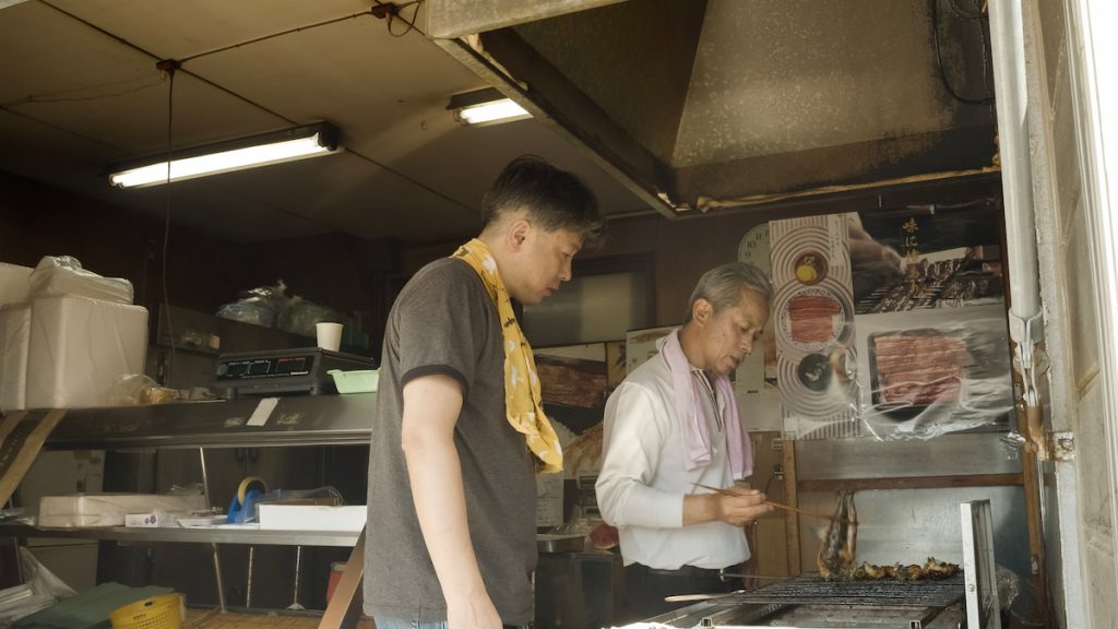 教導長女婿浩二如何判斷鰻魚熟度的輝章。