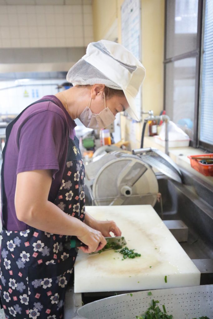 謝佳玲每日在龍肚國小廚房中切菜備料。