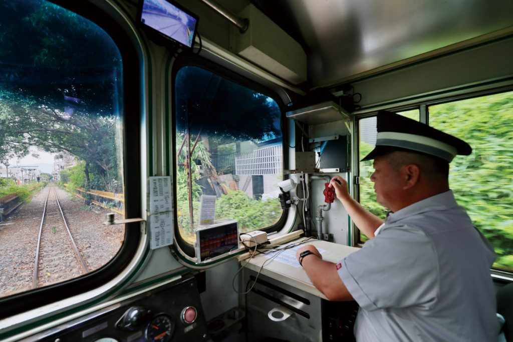 在守車內,列車長協助司機員監視前方路況。