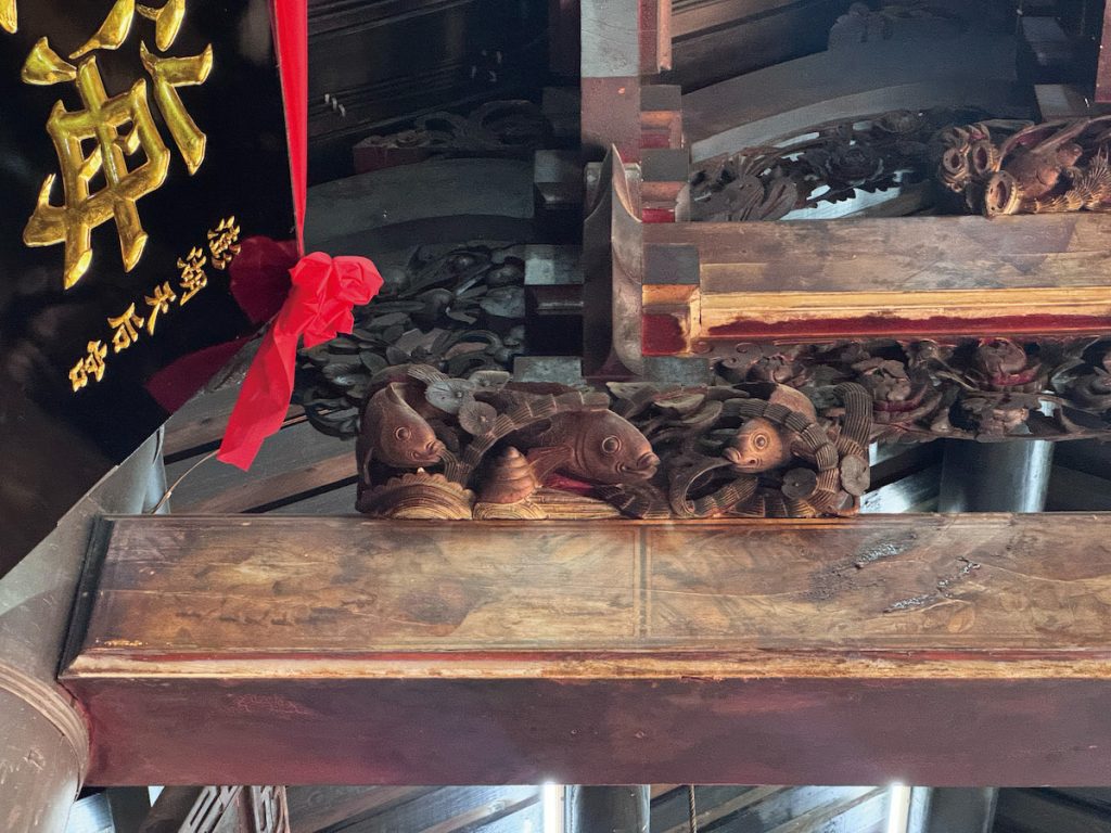 螺貝在古建木雕常現於水族群聚，寓意吉祥順遂、螺聲遠揚。
