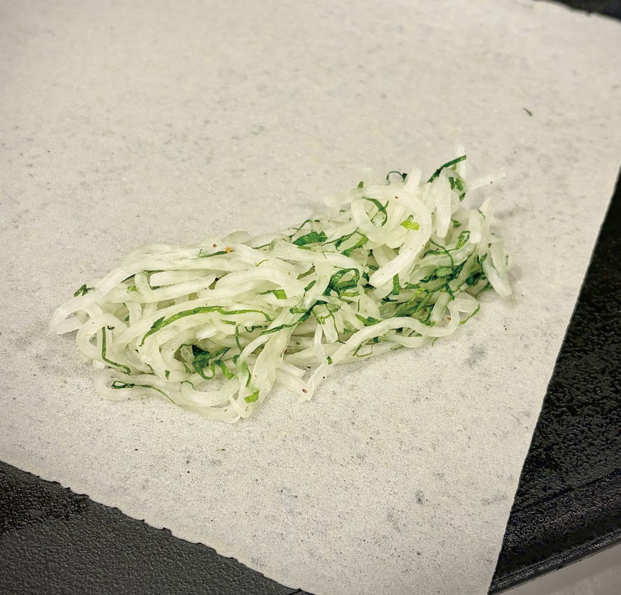 料理步驟
1 白蘿蔔削皮後刨成細絲。加入半小匙高湯鹽(或胡椒鹽)抓拌均勻,靜置片刻後用力擠出多餘水分。
2 紫蘇葉切成細絲,和蘿蔔絲拌勻,作為春捲內餡。喜歡紫蘇香氣的話可以多放一些。
3 將餡料放在春捲皮上,注意內餡,不要外露,包成細長型春捲。收口用清水即可。如春捲皮較大張,切成半張使用。